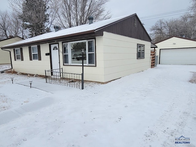 view of front of property featuring a garage and an outdoor structure