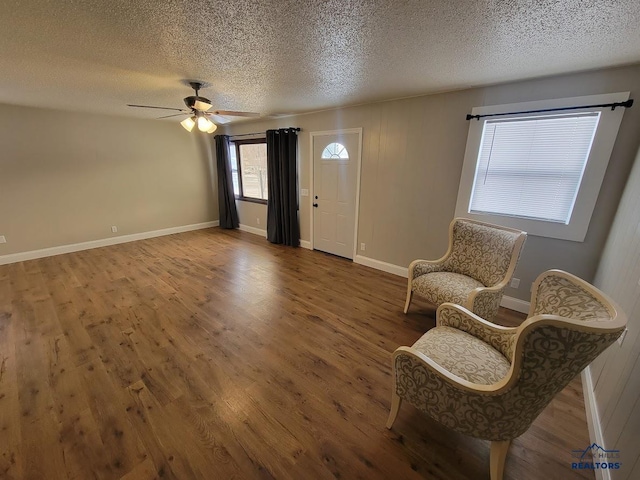 unfurnished room featuring ceiling fan, wood-type flooring, and a textured ceiling