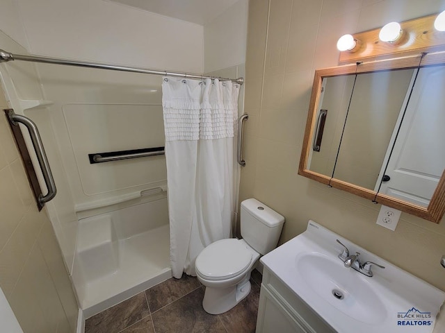 bathroom featuring vanity, toilet, tile walls, and a shower with shower curtain