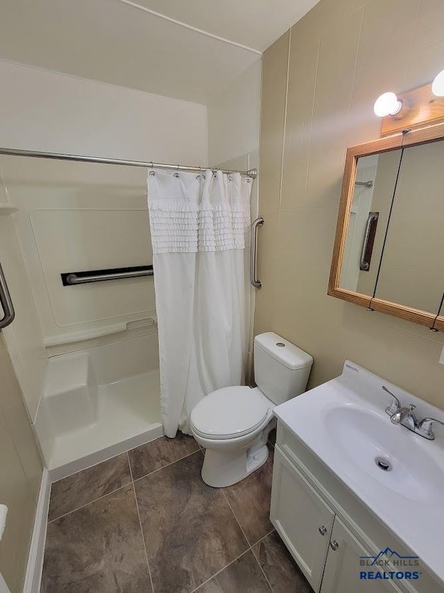 bathroom featuring vanity, curtained shower, and toilet