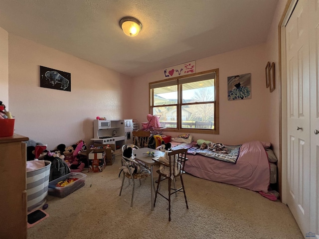 bedroom featuring a closet, a textured ceiling, and carpet