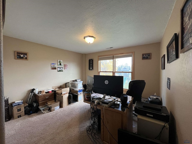 carpeted home office featuring a textured ceiling