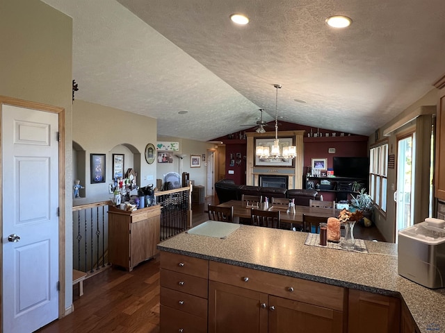 kitchen featuring dark wood-type flooring, lofted ceiling, decorative light fixtures, a textured ceiling, and ceiling fan