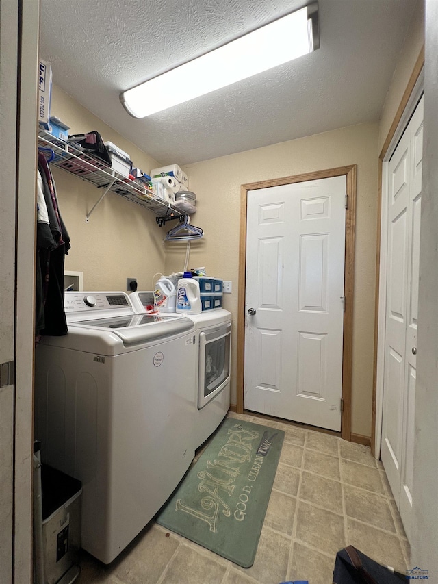 laundry area featuring separate washer and dryer and a textured ceiling