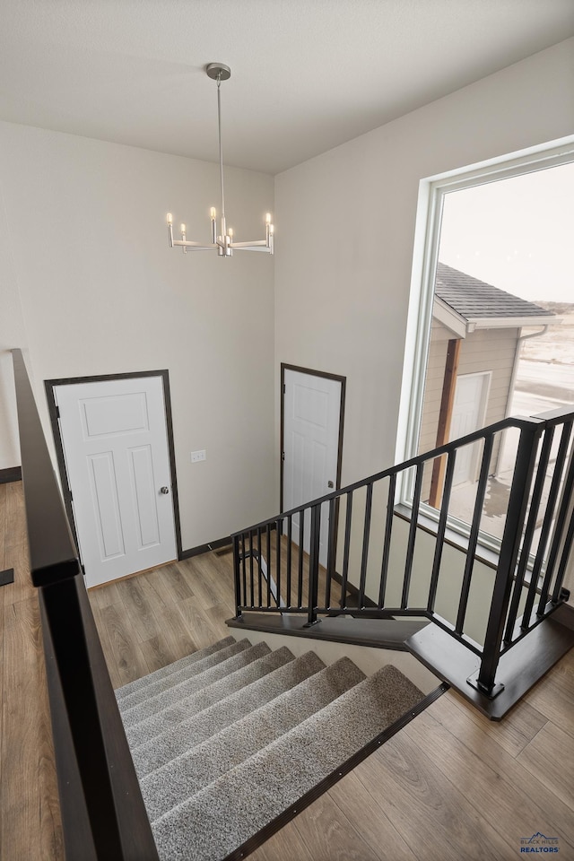 stairs featuring an inviting chandelier and hardwood / wood-style floors