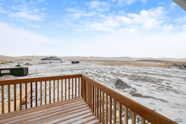 snow covered deck with a mountain view