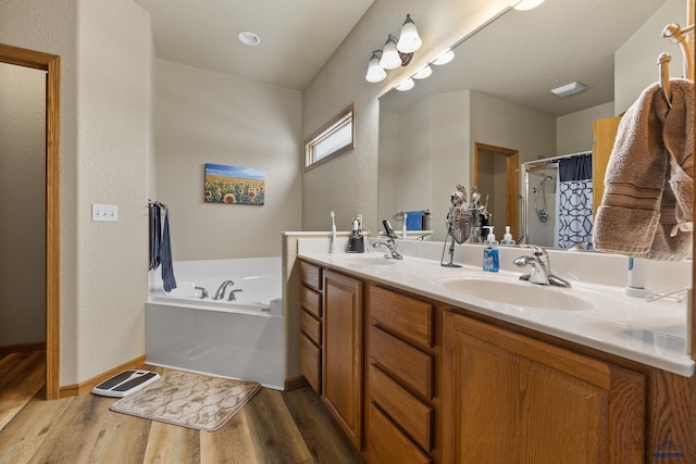 bathroom with hardwood / wood-style flooring, vanity, and independent shower and bath