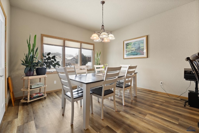 dining area with dark hardwood / wood-style flooring and a chandelier