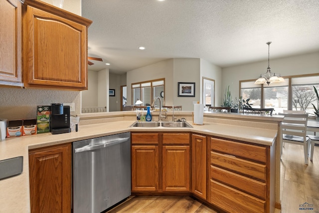 kitchen featuring sink, a textured ceiling, light hardwood / wood-style flooring, and dishwasher