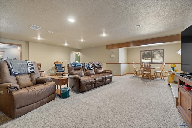 carpeted living room featuring a textured ceiling