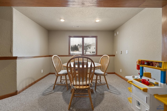 dining area with carpet and a textured ceiling