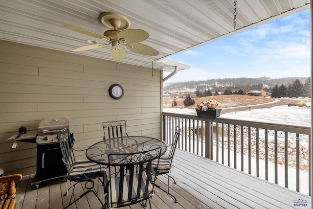 snow covered deck featuring ceiling fan, grilling area, and a mountain view