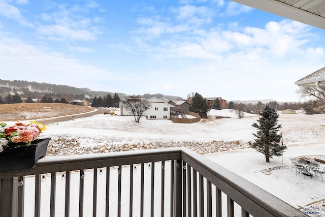 view of snow covered back of property