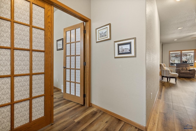 hallway with dark hardwood / wood-style flooring and a textured ceiling