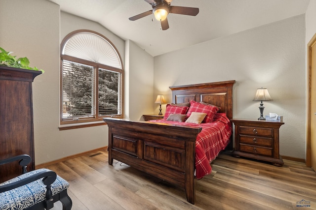 bedroom with ceiling fan, lofted ceiling, and hardwood / wood-style floors