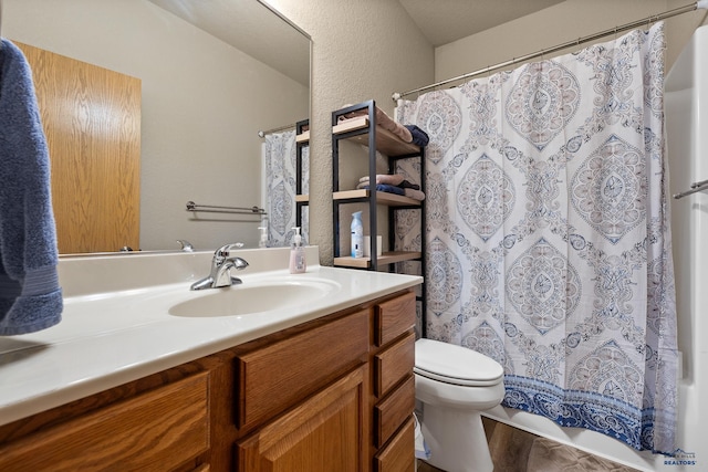 bathroom with hardwood / wood-style flooring, vanity, walk in shower, and toilet