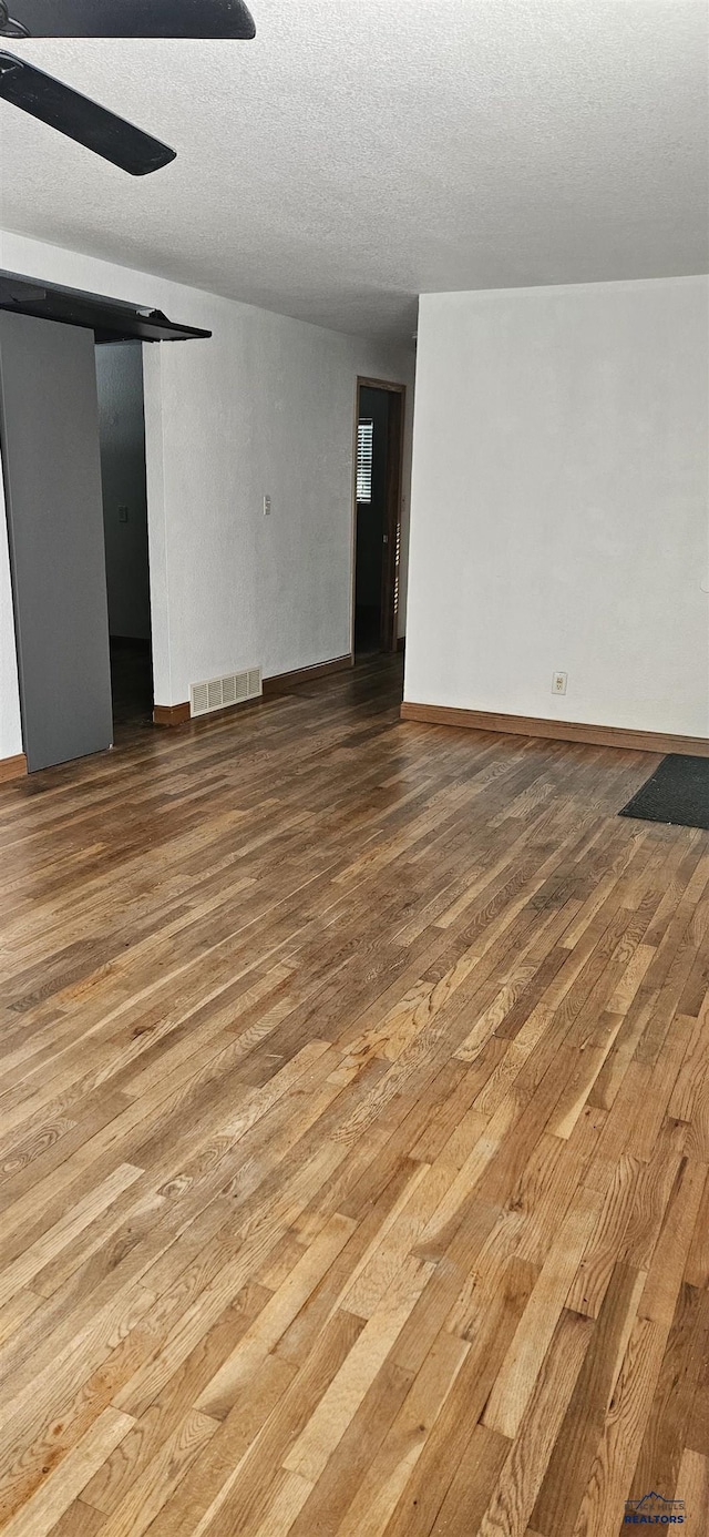 unfurnished room featuring hardwood / wood-style flooring, a textured ceiling, and ceiling fan