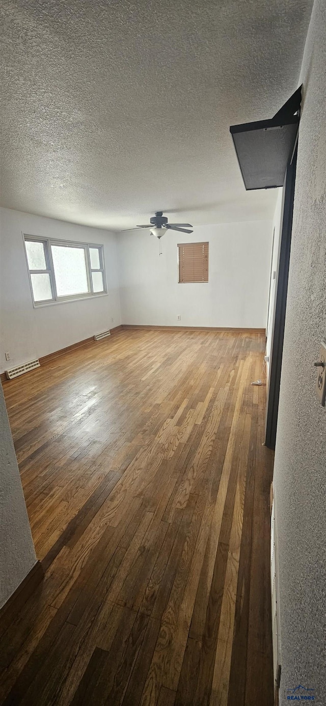 unfurnished living room with hardwood / wood-style floors, a textured ceiling, and ceiling fan