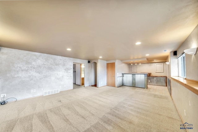 unfurnished living room featuring light colored carpet