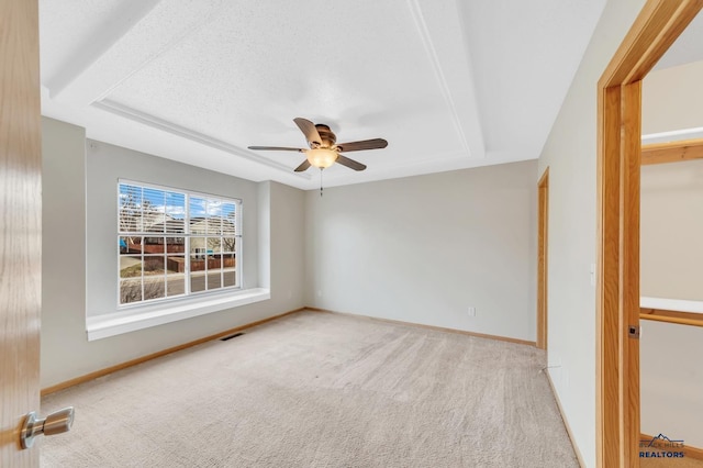 empty room featuring light carpet, a textured ceiling, and ceiling fan