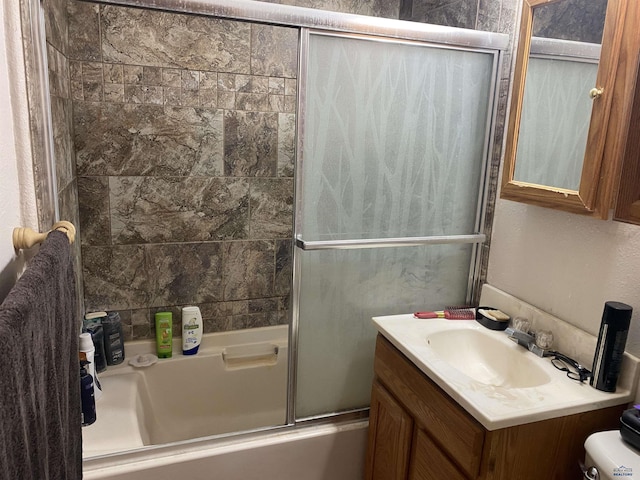 full bathroom featuring vanity, shower / bath combination with glass door, and toilet