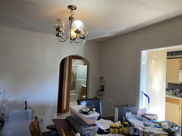 tiled dining space with a notable chandelier, ornamental molding, and a textured ceiling