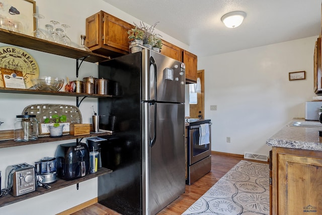 kitchen featuring sink, light hardwood / wood-style flooring, and stainless steel appliances