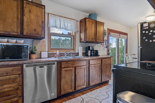 kitchen featuring dark wood-type flooring, sink, and black appliances