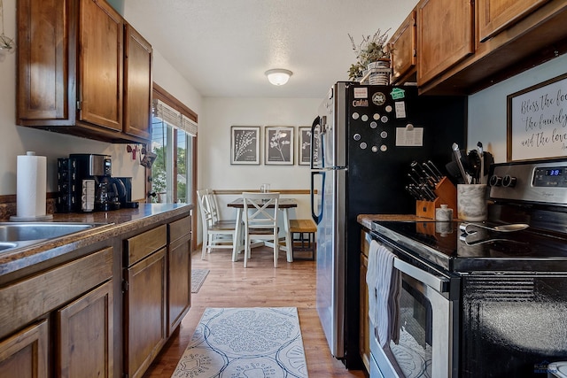 kitchen featuring stainless steel electric stove and light hardwood / wood-style flooring