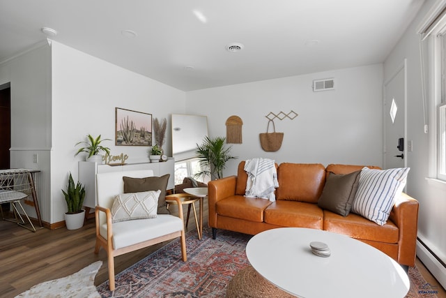 living room featuring baseboard heating and hardwood / wood-style flooring