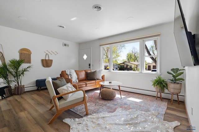 living room with a baseboard heating unit and dark wood-type flooring