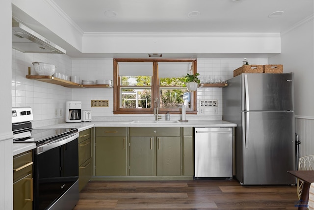 kitchen featuring sink, crown molding, appliances with stainless steel finishes, green cabinetry, and wall chimney exhaust hood