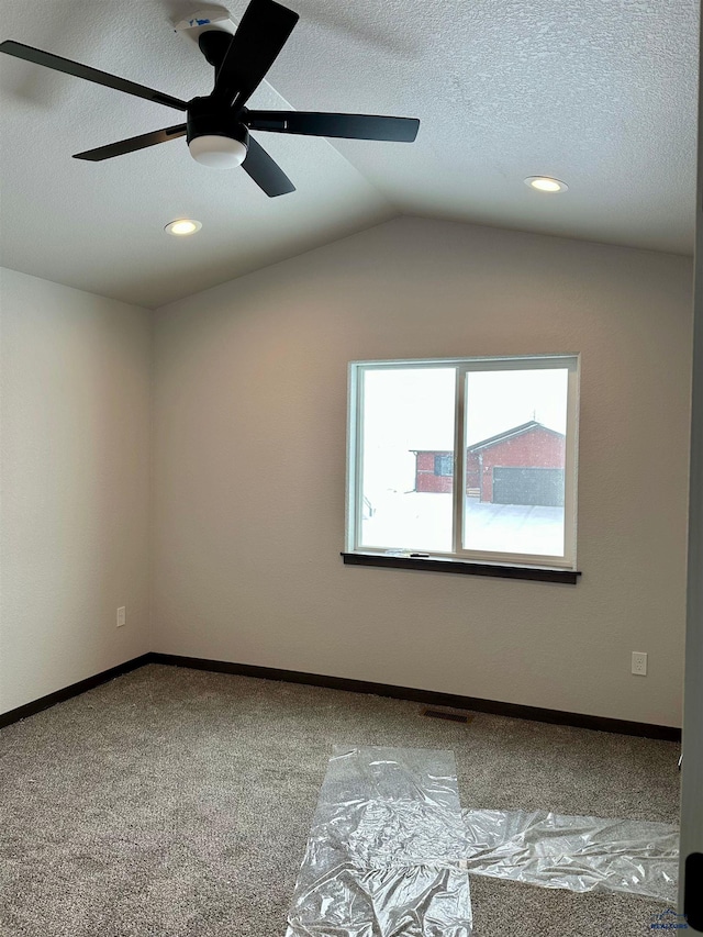 spare room with baseboards, vaulted ceiling, a textured ceiling, carpet floors, and recessed lighting