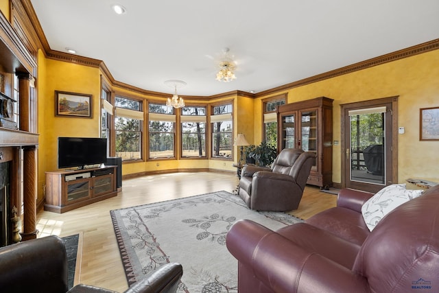 living room featuring ornamental molding, a fireplace, light hardwood / wood-style flooring, and a notable chandelier