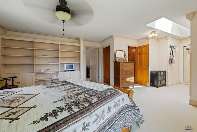 carpeted bedroom with ornamental molding, ceiling fan, and a skylight