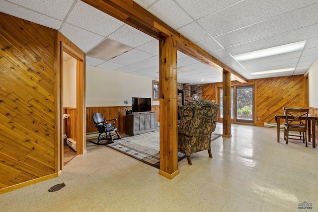 basement with a paneled ceiling and wooden walls