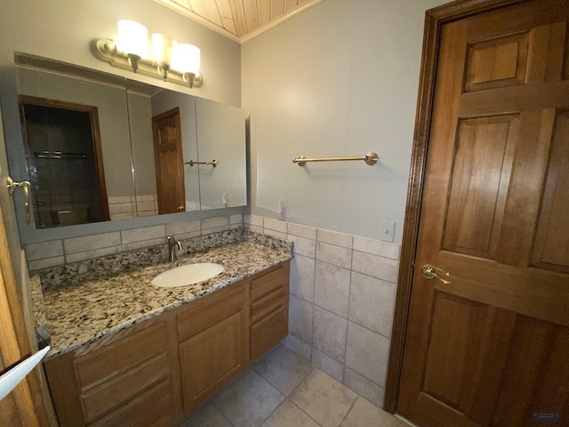 bathroom with tile walls, vanity, tile patterned flooring, and ornamental molding