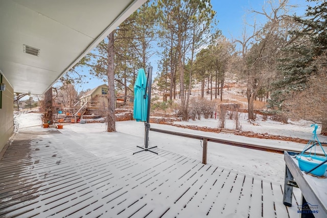 snow covered patio with a deck