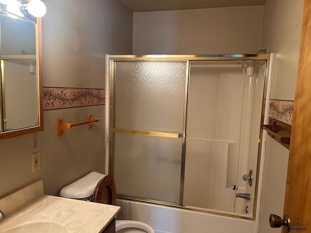 full bathroom featuring bath / shower combo with glass door, vanity, and toilet