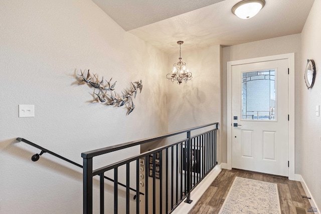 foyer featuring an inviting chandelier and dark hardwood / wood-style floors