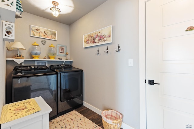 clothes washing area with dark wood-type flooring and washer and clothes dryer