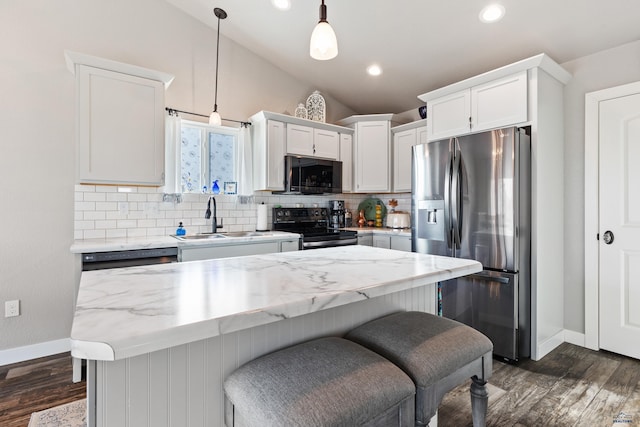 kitchen featuring sink, decorative light fixtures, black appliances, a kitchen island, and white cabinets