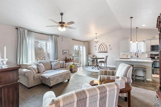 living room featuring lofted ceiling, sink, dark hardwood / wood-style flooring, and ceiling fan