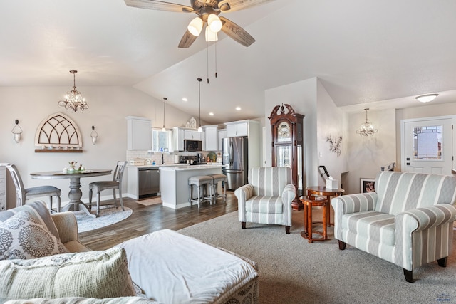 living room featuring dark wood-type flooring, lofted ceiling, sink, and ceiling fan with notable chandelier