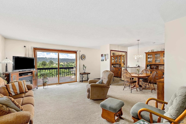 living room with a chandelier, light carpet, and a textured ceiling