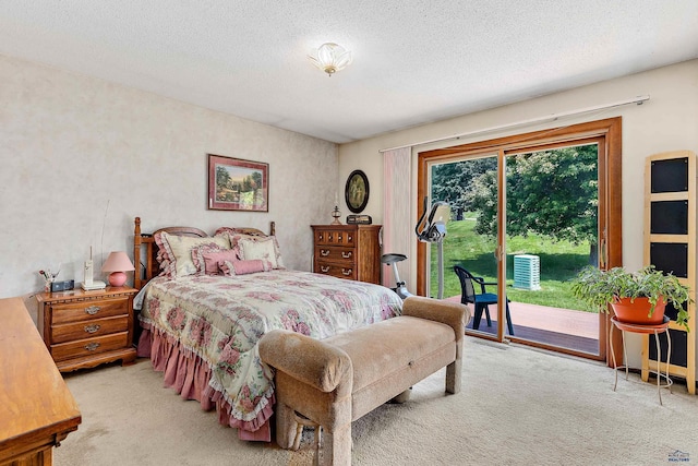 carpeted bedroom featuring a textured ceiling and access to outside