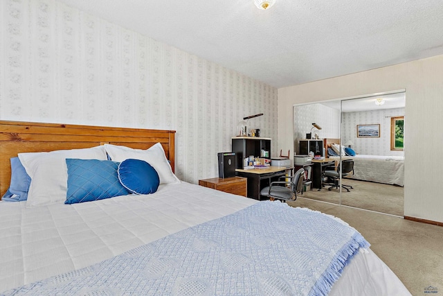 bedroom featuring light carpet, a textured ceiling, and a closet