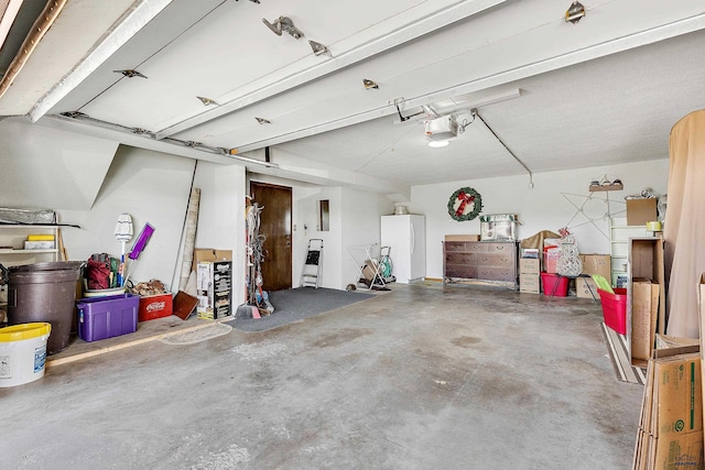 garage featuring white refrigerator and a garage door opener