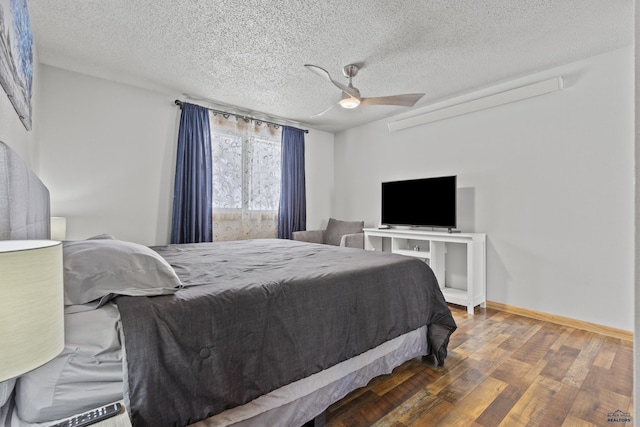 bedroom with a textured ceiling, dark wood-type flooring, and ceiling fan