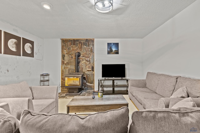 living room with a textured ceiling and a wood stove